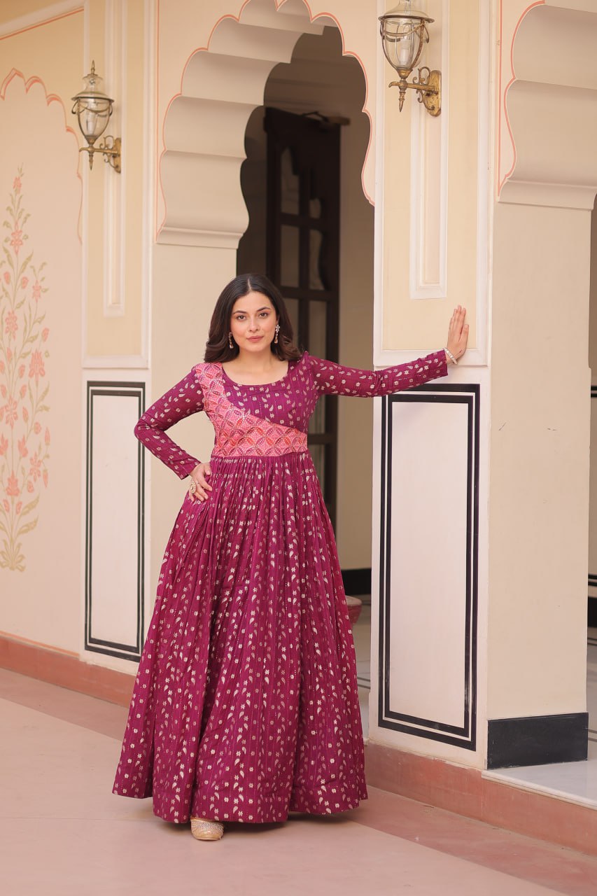 Vani Choli Printed Wine Color Gown with staple jacquard fabric, full sleeves, cotton lining, and 3-meter flare – perfect ethnic party wear gown for wedding functions, festive nights, and modern Indian women.