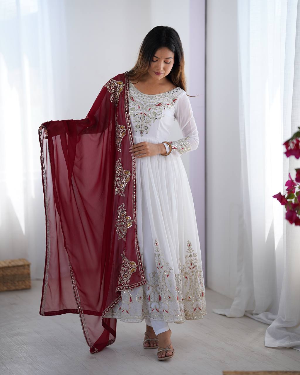 Tejvini White Embroidered Gown Set – heavy georgette gown with multi-thread 5mm sequin embroidery, full sleeves, soft cotton inner, paired with contrasting maroon embroidered dupatta and stitched bottom – ideal for weddings, receptions, and festive occasions.