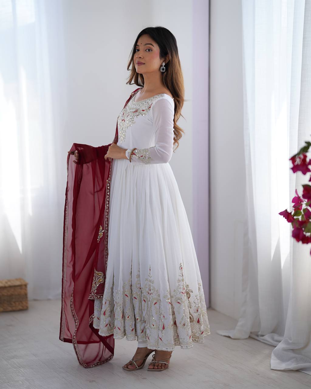 Tejvini White Embroidered Gown Set – heavy georgette gown with multi-thread 5mm sequin embroidery, full sleeves, soft cotton inner, paired with contrasting maroon embroidered dupatta and stitched bottom – ideal for weddings, receptions, and festive occasions.