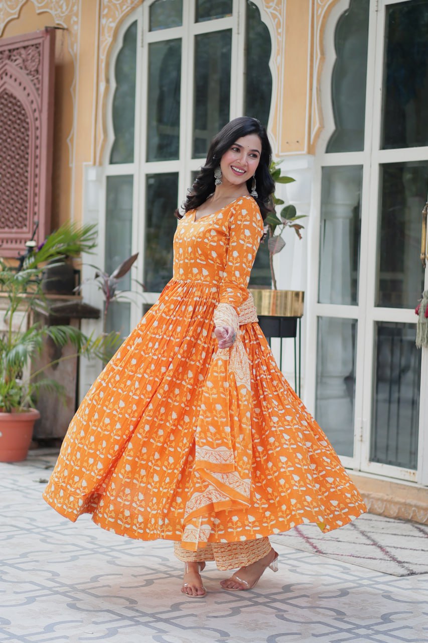 The Ridhvini Orange Pure Cotton Printed Anarkali Set is a stylish and breathable cotton Anarkali suit for women, perfect for daily wear, office wear, and festive occasions. Made from premium pure cotton, this readymade Anarkali kurta set offers comfort and elegance with a flowing silhouette, fancy V-neck, and full sleeves. Paired with straight cotton pants and a matching dupatta, this ethnic cotton suit is ideal for summer fashion. Whether you're looking for a lightweight festive outfit or a printed Anarkal