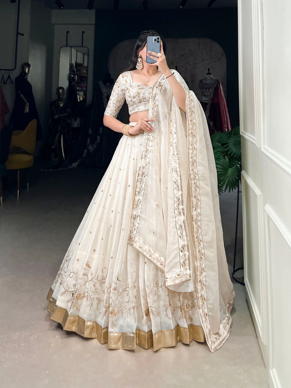 The **Dharvika Off-White Embroidered Lehenga Choli** is a masterpiece of elegance, designed for those who appreciate regal charm with a modern touch. Crafted from **luxurious Silver Glossy fabric**, this **designer lehenga choli** is adorned with **sequins, intricate embroidery, and foil work**, making it an ideal choice for **weddings, receptions, sangeet, and festive celebrations like Diwali**.

With a **majestic 3.5-meter flair**, stitched **canvas and can-can lining**, and a **soft micro cotton inner**,