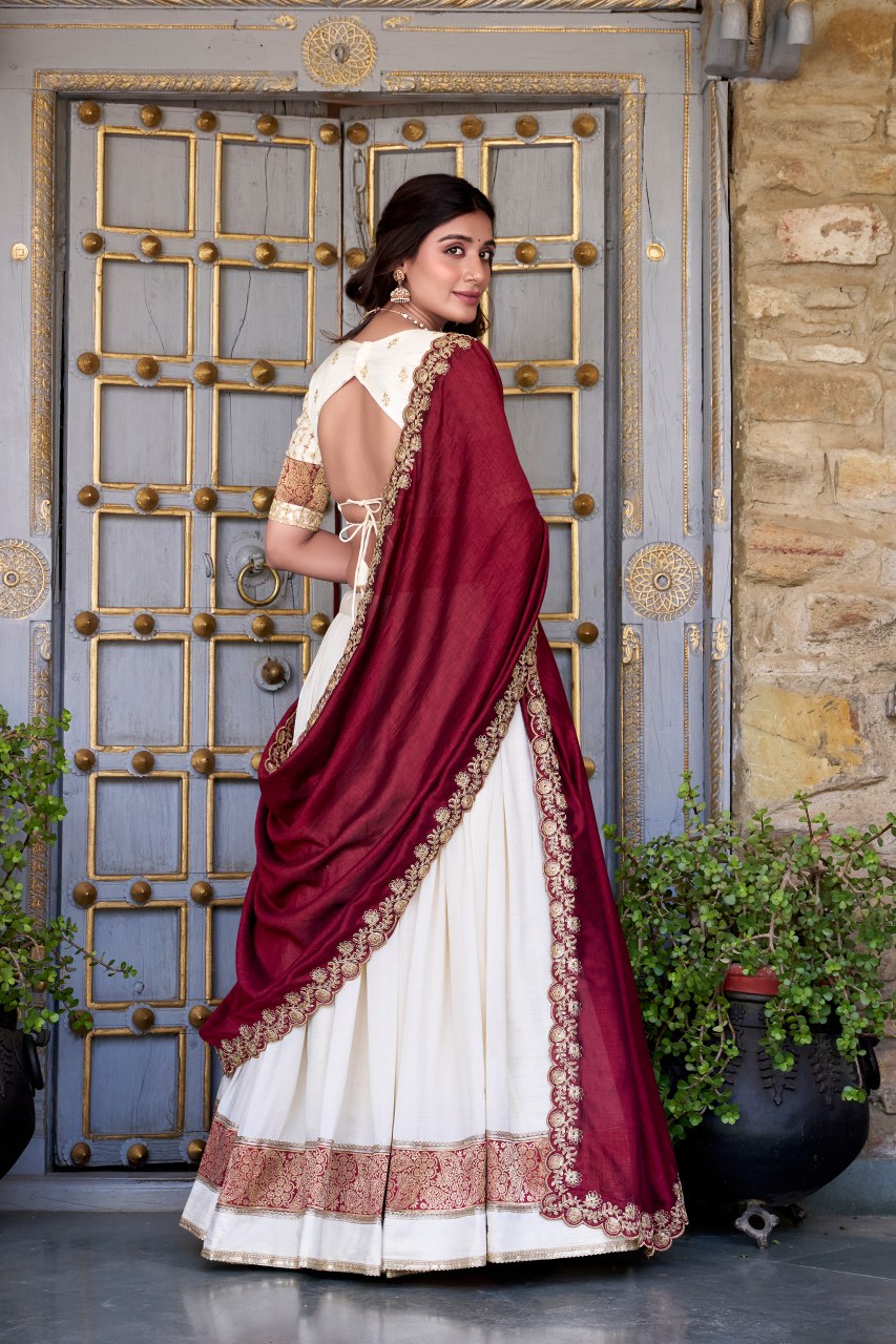 Off-white Vichitra silk lehenga choli set featuring zari weaving, sequins lace border, and embroidered dupatta ideal for weddings and festive celebrations.