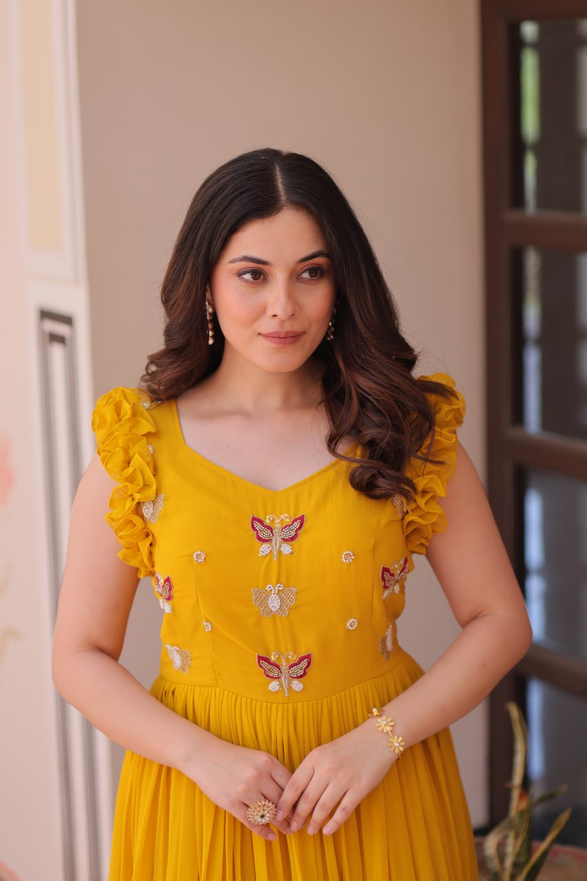 Lavi 7-meter flared designer gown in faux blooming fabric with sequin & bead embroidery, V-neck & frill shoulders – perfect for weddings & parties.