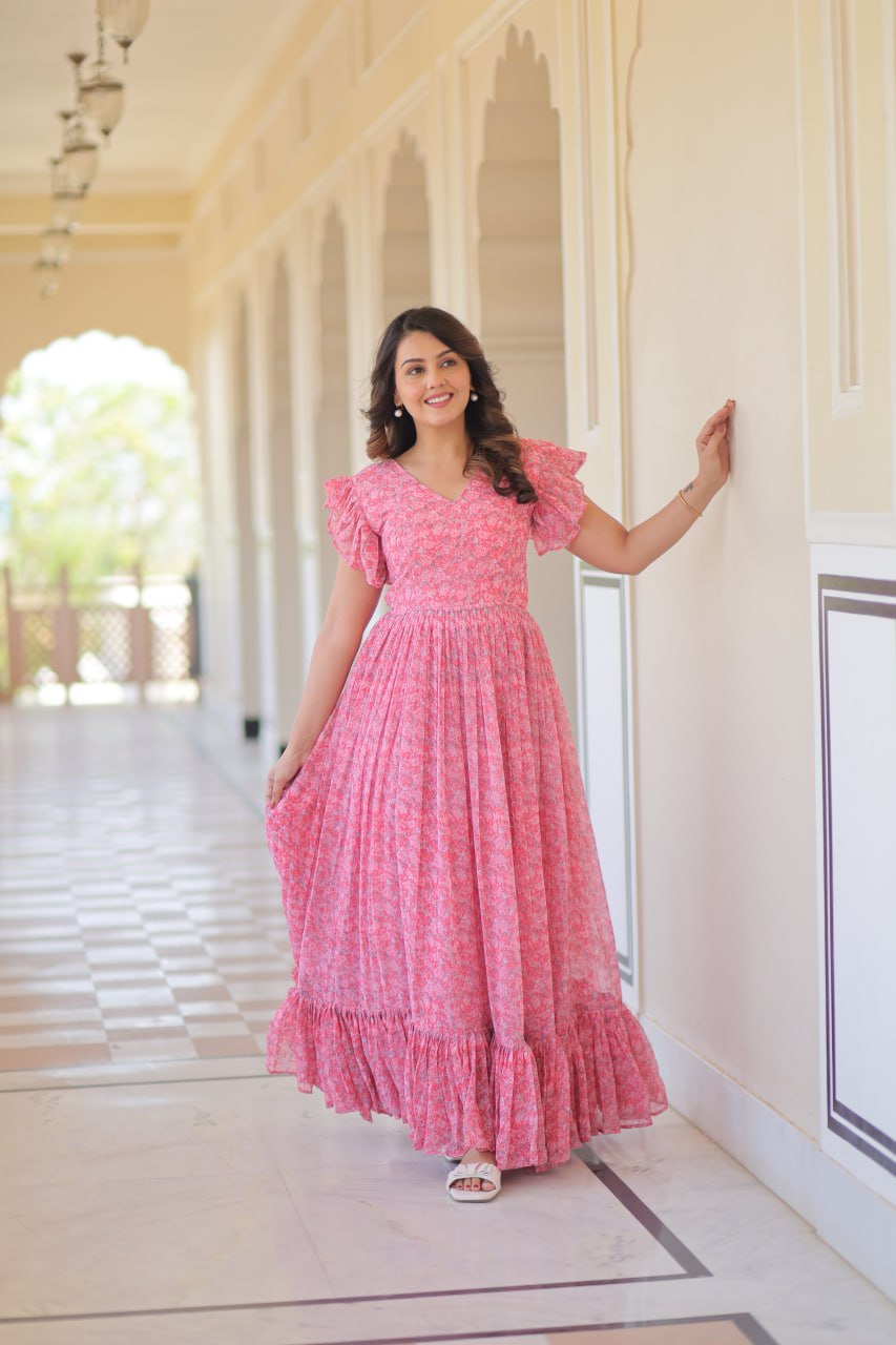Printed pink georgette gown for women with 7-meter flair, bell sleeves & V-neck—lightweight ethnic dress for Haldi, Mehendi, Navratri & festive functions.