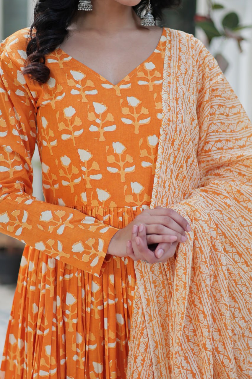 The Ridhvini Orange Pure Cotton Printed Anarkali Set is a stylish and breathable cotton Anarkali suit for women, perfect for daily wear, office wear, and festive occasions. Made from premium pure cotton, this readymade Anarkali kurta set offers comfort and elegance with a flowing silhouette, fancy V-neck, and full sleeves. Paired with straight cotton pants and a matching dupatta, this ethnic cotton suit is ideal for summer fashion. Whether you're looking for a lightweight festive outfit or a printed Anarkal